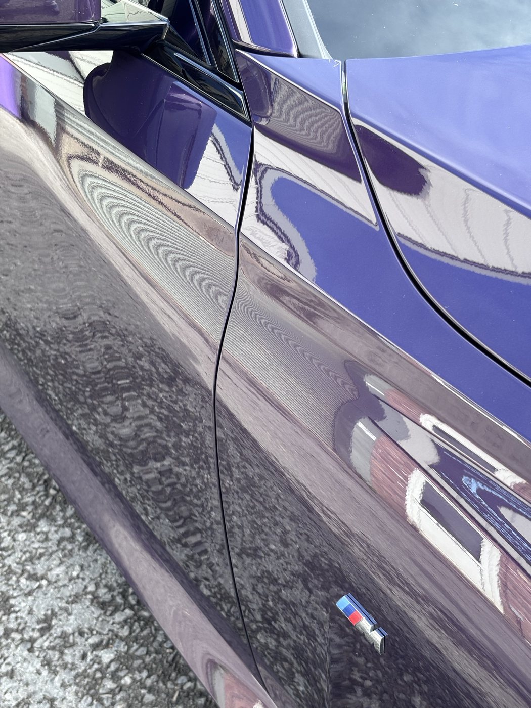 Mirror-like reflections across the coated flank of a purple BMW 220i