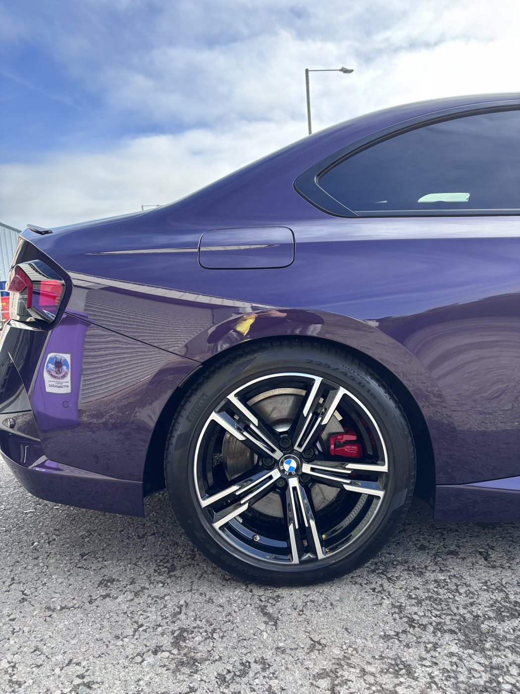 Coated rear quarter and wheel of a purple BMW 220i