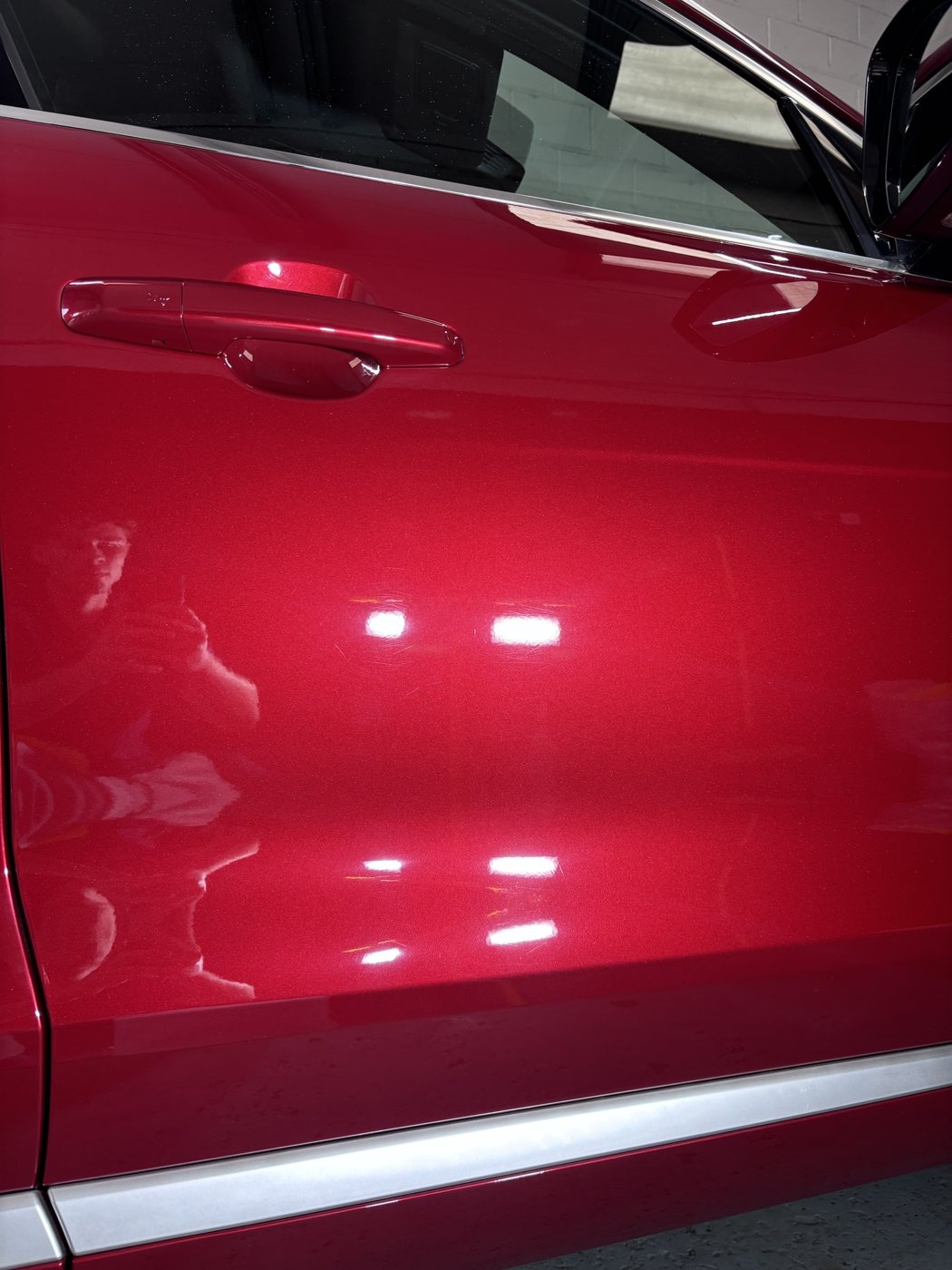 The same red door after machine paint correction, swirls and scratches removed